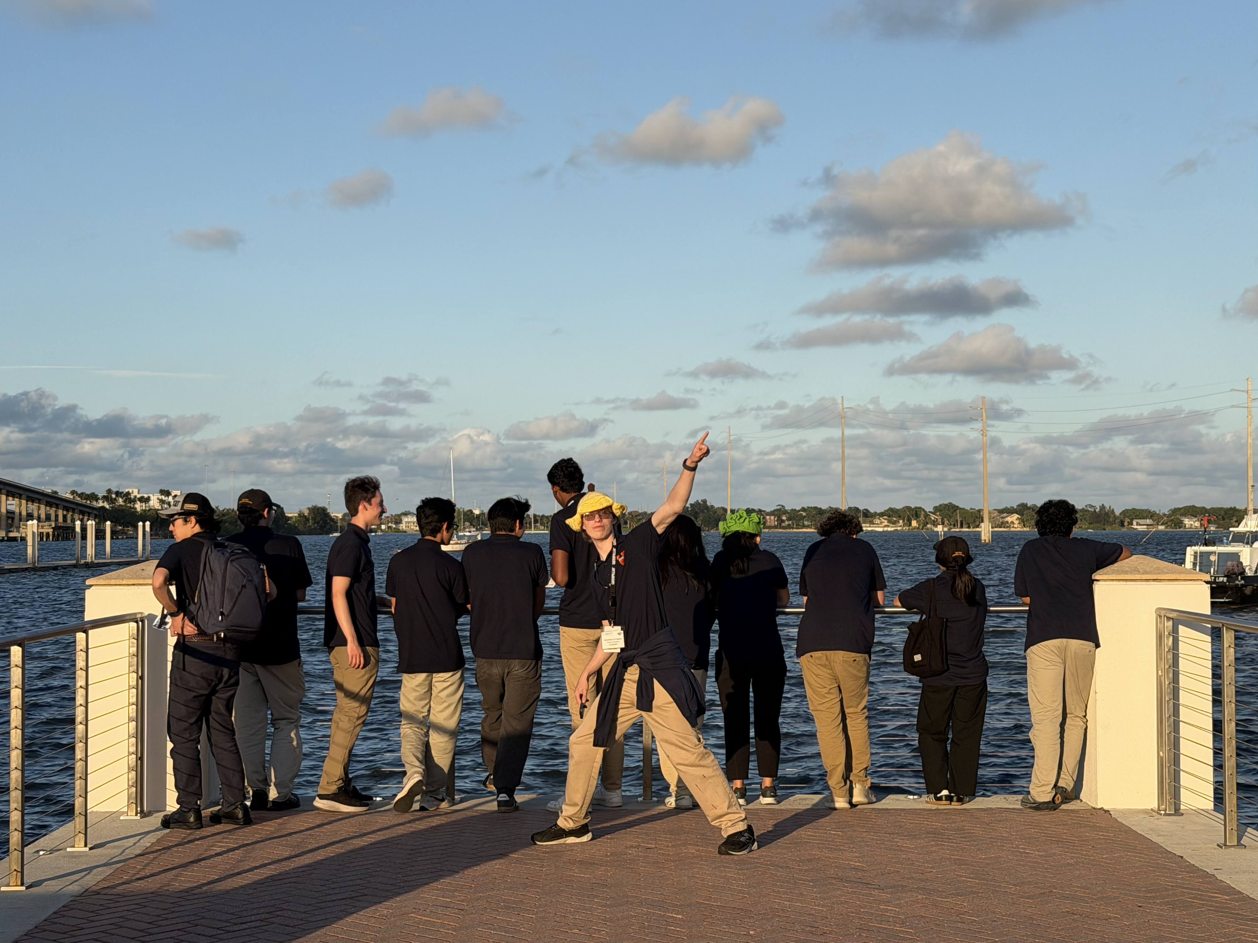 Ethan Edwards pointing at the water with teammates on a pier